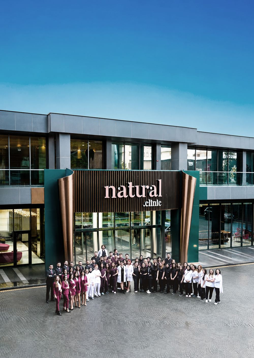 The natural.clinic team standing in front of the clinic entrance in Istanbul, beneath the signage